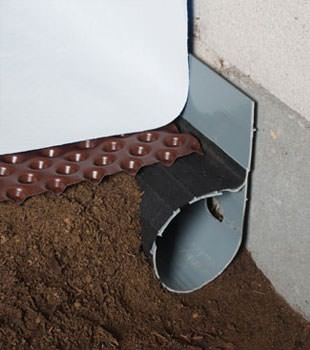 Closeup of a crawl space drainage system installed in Baldwin
