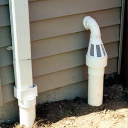 A grated sump pump discharge line fitting in Manhasset